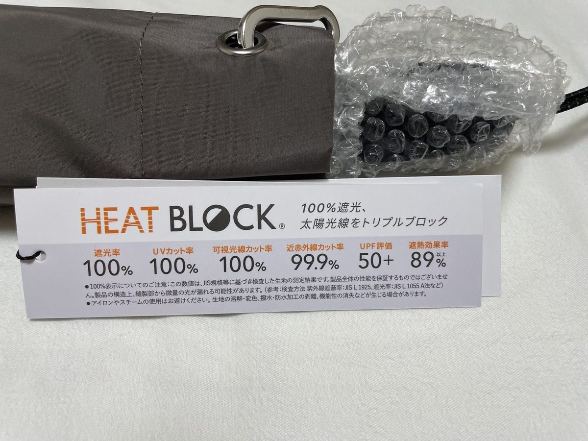 HEAT BLOCKの実物タグ ― 遮光率100%・UVカット率100%・UPF50+の表示